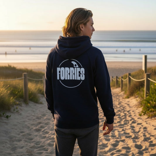 Sideliners navy blue unisex hoodie with a white Forries circular logo on the back, worn by a man at the beach.